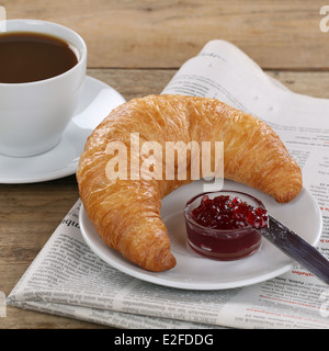 Petit-déjeuner d'affaires avec un croissant, confiture, café et un journal Banque D'Images