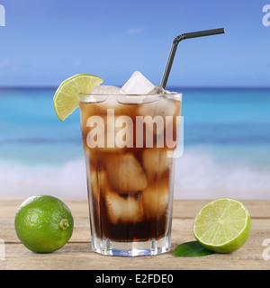 Cola ou cocktail Cuba Libre boire dans du verre, avec des cubes de glace sur la plage Banque D'Images