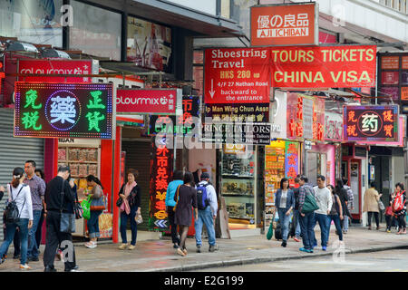 Chine Hong Kong Kowloon District Peking Road aller et venir de piétons sur un trottoir en passant en face d'un Chinois Banque D'Images