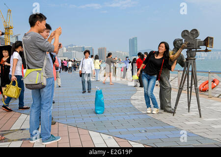 Chine Hong Kong Kowloon Avenue des Stars District touristique asiatique se faire photographier devant une statue de bronze symbolisant une Banque D'Images