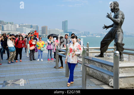 Chine Hong Kong Kowloon Avenue des Stars District touristique asiatique se faire photographier devant une statue de bronze de l'acteur Banque D'Images