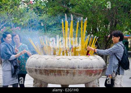 Chine Hong Kong l'île de Lantau Monastère de Ngong Ping Pol Lin croyant mettre du dépôt de bâtons d'encens Banque D'Images