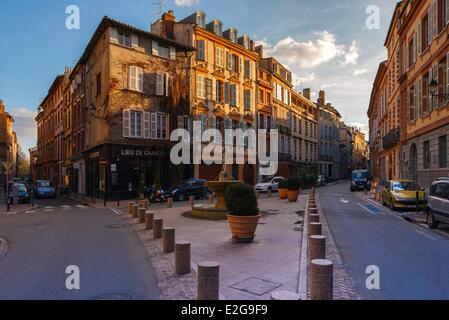 France Haute Garonne Toulouse Place Saintes Scarbes Saint Etienne fontaine avec une statue au milieu d'un carré au coucher du soleil Banque D'Images