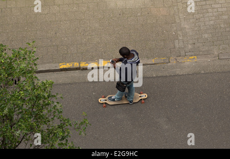 Une photographie d'un skateur professionnel skating alors que des messages sur le téléphone. Une combinaison dangereuse. Banque D'Images