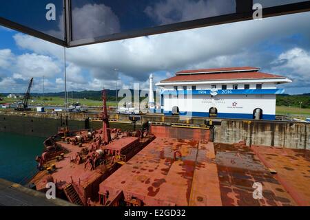 La province de Colon Panama Canal de Panama écluses de Gatun mules mécaniques ou électriques locomotives le guidage d'un cargo de type Panamax entre murs de blocage Banque D'Images