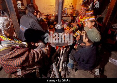 Vallées Kalash Khyber Pakhtunkhwa au Pakistan vallée Bumburet repas de famille autour de cuisinière en Kalash chambre single homes en utilisant pour cuisiner et pas à la chaleur au sol en terre avec bois et murs et enduits Banque D'Images