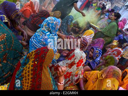 État de l'Uttar Pradesh Inde Mathura femmes jettent des fleurs au cours des célébrations du festival Holi Banque D'Images