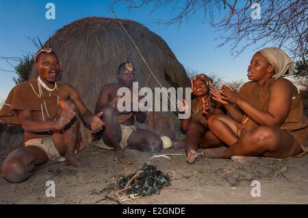 Botswana Réserve de gibier du Kalahari central kalahari Plains Camp Lodge Wilderness Safaris à pied avec l'éducation traditionnelle de Bushmen hut fait de brindilles et de paille par le feu des chansons de chasse Banque D'Images