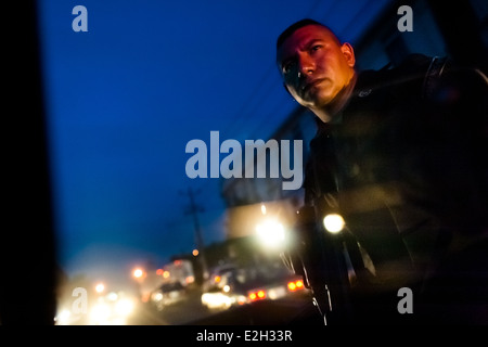 Un policier de l'unité spéciale d'urgence (Halcones) montres la rue à partir d'un véhicule conduite à San Salvador, El Salvador. Banque D'Images