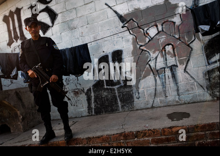 Un policier de l'unité spéciale d'urgence (Halcones) Patrouilles dans un quartier d'un gang de San Salvador, El Salvador. Banque D'Images