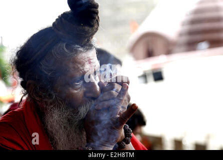 Guwahati, Inde. 19 Juin, 2014. Un saint homme indien ou ganja bouffées de tabac local dans les locaux du temple Kamakhya en avant de l'Ambubasi annuel festival qui commencera à partir de dimanche à Guwahati, Inde, le 19 juin 2014. Credit : Stringer/Xinhua/Alamy Live News Banque D'Images