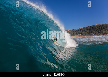 Surf Surfer rides creuses à l'intérieur bleu océan vague s'écraser en métro. Banque D'Images