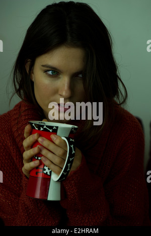 Woman in sweater holding mug, portrait Banque D'Images