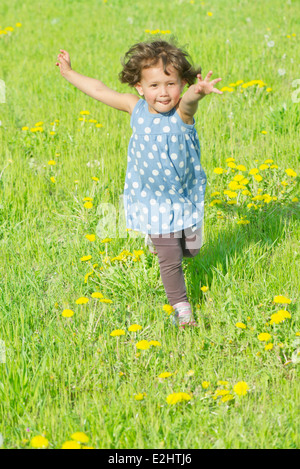 Petite fille courir dans le pré Banque D'Images