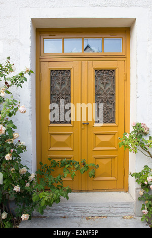 Un beau jaune porte entourée de roses dans une rue de la ville médiévale de Visby, Gotland, Suède Banque D'Images