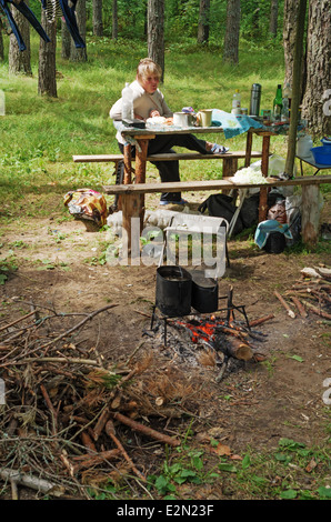 Les touristes reste près d'un incendie dans la forêt. Banque D'Images