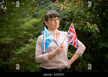 Jeune femme à la recherche d'un drapeau britannique et écossais de décider comment voter dans le référendum sur l'indépendance écossaise Banque D'Images