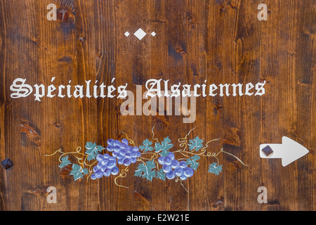 Panneau en bois afficher le texte   spécialités alsaciennes sur la façade d'un restaurant à Eguisheim, Alsace, France Banque D'Images