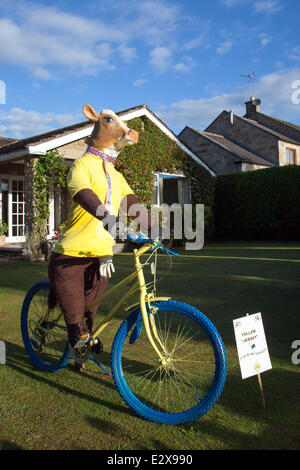 Gros animal en peluche vache Sawley, Yorkshire Dales National Park, Royaume-Uni. 21 juin 2014. "Le bétail sur un vélo' un jardin afficher d'une vache sur un vélo ; Yorkshire se prépare pour le Tour de France par décorer la route avec les vélos jaunes et bannières à mesure que les entreprises se préparent pour la plus grande course à vélo - le Tour de France - qui débutera dans le comté sur 5e & 6e juillet 2014 réunissant des millions de fans à la bordure du Yorkshire pour applaudir les champions du sport. Ce sera la première fois le Tour a visité le nord de l'Angleterre après avoir fait des visites uniquement à la côte sud et de la capitale. Banque D'Images