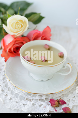 Tasse de thé avec des roses roses fraîches et séchées Banque D'Images
