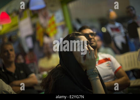 Téhéran, Iran. 21 Juin, 2014. Le 21 juin 2014 - Téhéran, Iran - une jeune femme iranienne de la FIFA Coupe du Monde 2014 montres match de football entre l'Iran et l'Argentine, dans un café du nord de Téhéran. Morteza Nikoubazl/ZUMAPRESS : Morteza Nikoubazl Crédit/ZUMA/ZUMAPRESS.com/Alamy fil Live News Banque D'Images