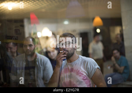 Téhéran, Iran. 21 Juin, 2014. Le 21 juin 2014 - Téhéran, Iran - un Iranien de bouffées sur une cigarette tout en regardant la Coupe du Monde FIFA 2014 match de football entre l'Iran et l'Argentine, dans un café du nord de Téhéran. Morteza Nikoubazl/ZUMAPRESS : Morteza Nikoubazl Crédit/ZUMA/ZUMAPRESS.com/Alamy fil Live News Banque D'Images