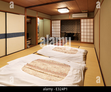 Chambre traditionnelle japonaise dans un ryokan avec futons sur le plancher. Kyoto, Japon. Banque D'Images