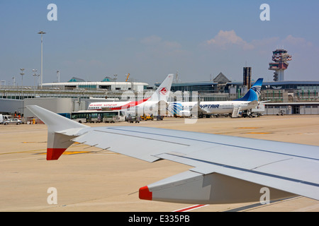 Vue depuis l'avion à réaction passager jusqu'à la piste italienne passant par la tour de contrôle et l'avion au terminal de l'aéroport Rome Fiumicino en Italie Banque D'Images