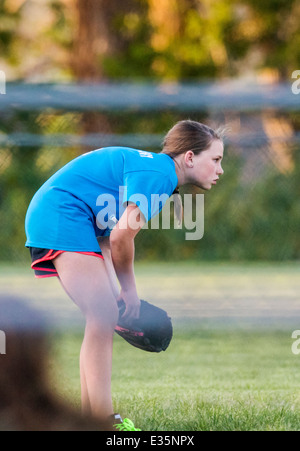 Teenage girl playing softball sur une chaude soirée d'été. Banque D'Images