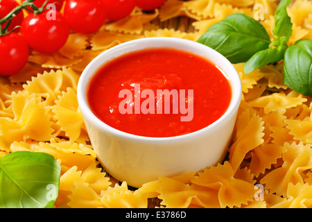 Noeud papillon non cuit des pâtes et de la purée de tomates Banque D'Images