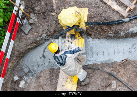 Les travailleurs de la construction pour le béton dans un fossé. Temps de pluie. Vue à vol d'oiseau. Banque D'Images