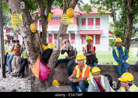 Les travailleurs migrants de prendre une pause de leur travail sur un chantier de construction dans le centre de Kuala Lumpur, Malaisie Banque D'Images