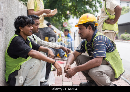 Les travailleurs migrants de prendre une pause de leur travail sur un chantier de construction dans le centre de Kuala Lumpur, Malaisie Banque D'Images