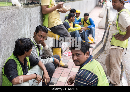 Les travailleurs migrants de prendre une pause de leur travail sur un chantier de construction dans le centre de Kuala Lumpur, Malaisie Banque D'Images