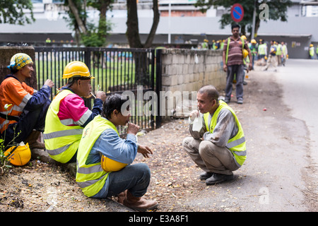 Les travailleurs migrants de prendre une pause de leur travail sur un chantier de construction dans le centre de Kuala Lumpur, Malaisie Banque D'Images