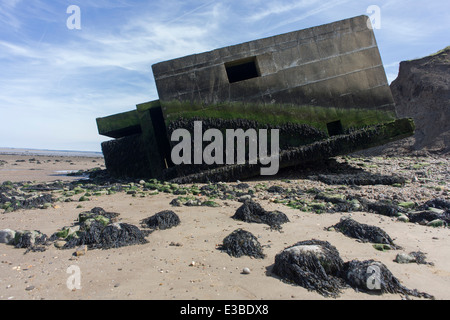 WW2-casemate béton ère défense structure se trouve sur la plage après l'érosion côtière au point des gardes, à l'île de Sheppey, Kent. Banque D'Images