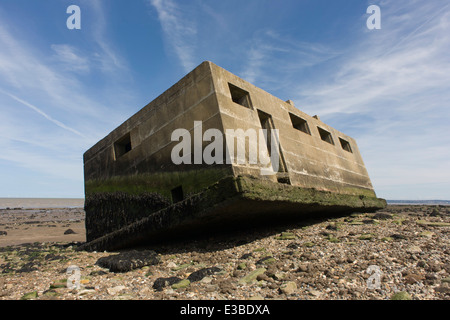 WW2-casemate béton ère défense structure se trouve sur la plage après l'érosion côtière au point des gardes, à l'île de Sheppey, Kent. Banque D'Images