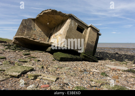 WW2-casemate béton ère défense structure se trouve sur la plage après l'érosion côtière au point des gardes, à l'île de Sheppey, Kent. Banque D'Images