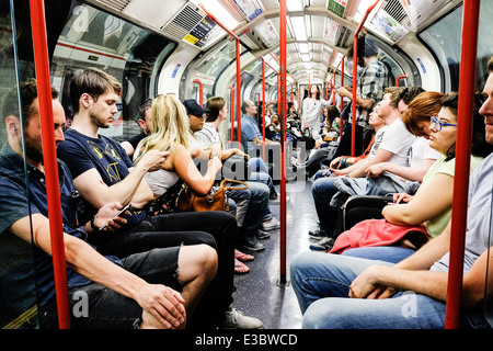 Passagers voyageant dans un wagon de métro londonien au Royaume-Uni. Banque D'Images