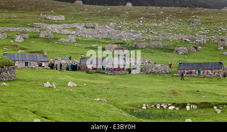 Les touristes explorant les blackhouses abandonné sur la rue principale dans la baie du Village, St Kilda Banque D'Images