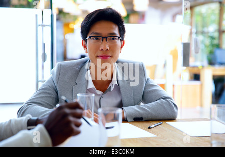 Portrait of asian man sitting at table in office Banque D'Images