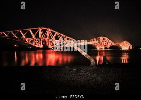 Un coup en fin de soirée des courts de Forth Rail Bridge avec un flash lumineux d'ancrage des bateaux au premier plan. Banque D'Images