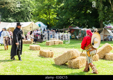 Poireau, Staffordshire, Angleterre. 22 juin 2014, un week-end country et western. Deux cowboys tirer leurs armes les uns sur les autres Banque D'Images