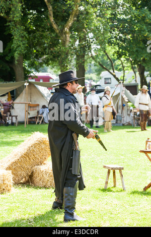 Poireau, Staffordshire, Angleterre. 22 juin 2014, un week-end country et western. Cowboy vêtu de noir l'arme au poing. Banque D'Images