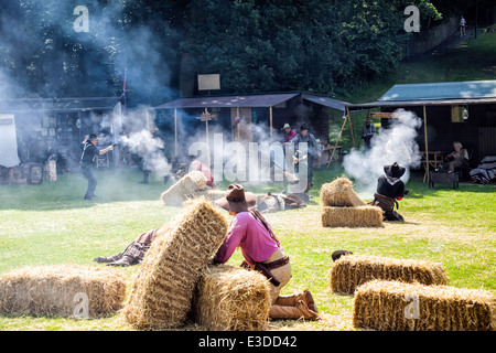 Poireau, Staffordshire, Angleterre. 22 juin 2014, un week-end country et western. Cowboys tirant leurs armes à l'autre. Banque D'Images