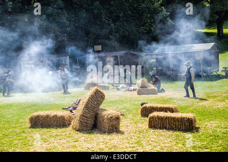 Poireau, Staffordshire, Angleterre. 22 juin 2014, un week-end country et western. Cowboys tirant leurs armes à l'autre. Banque D'Images