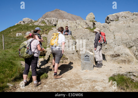 Les marcheurs par signer au Crib Goch path au Bwlch y Moch début de Snowdon horseshoe en montagnes de Snowdonia. Le Nord du Pays de Galles Royaume-uni Grande-Bretagne Banque D'Images