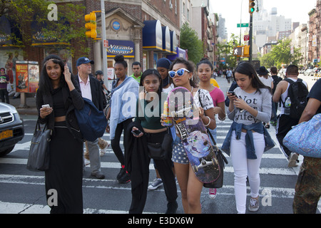 Les filles de l'adolescence croix de 1ère ave le long de la 14e Rue après l'école à Manhattan, New York. Banque D'Images