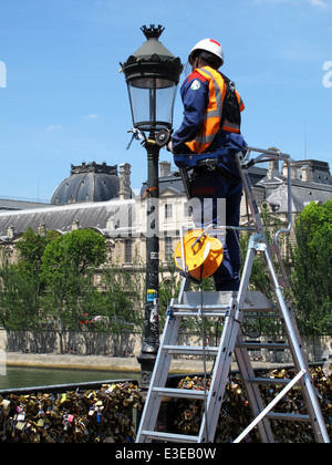 Retrait des travailleurs sur cadenas d'amour pont Pont des Arts sur la Seine, Paris, France, musée du Louvre Banque D'Images