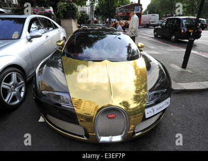 Les passants s'arrêter pour vérifier deux voitures flashy garé à l'extérieur de la face de l'Hôtel Dorchester. Une Lamborghini Aventador violet et jaune et or Bugatti Veyron. En vedette : Bugatti Veyron Où : London, Royaume-Uni Quand : 20 Oct 2013 Banque D'Images